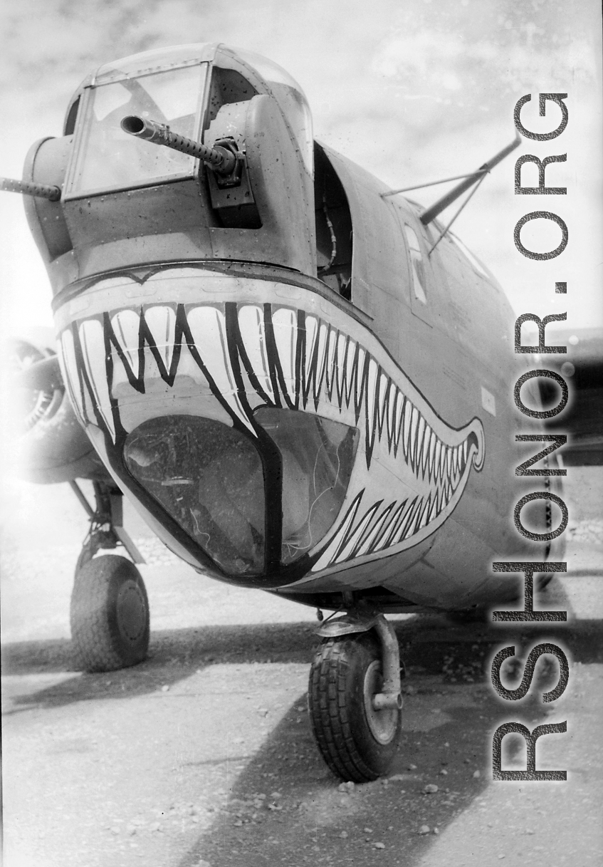 A shark-mouth B-24, the mouth having a unique curl at the back, in a revetment in SW China, likely Sichuan, during WWII. This is a later model B-24 as indicated by the nose turret with two .50 cal machine  guns.