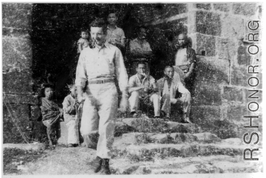 GI walking from gate in city wall in SW China, during WWII.