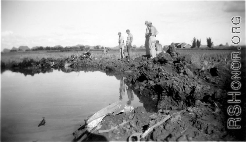 GIs look over devastating crash site of an American aircraft--the bent .50 cal machine gun in one image indicates it is American, and the gun mounting is like that of the nose gun of some B-25 Mitchells.  In this image set, the intensity by which people are searching the crash site, and the solemn nature of it all, makes one wonder if they are not looking for human remains.