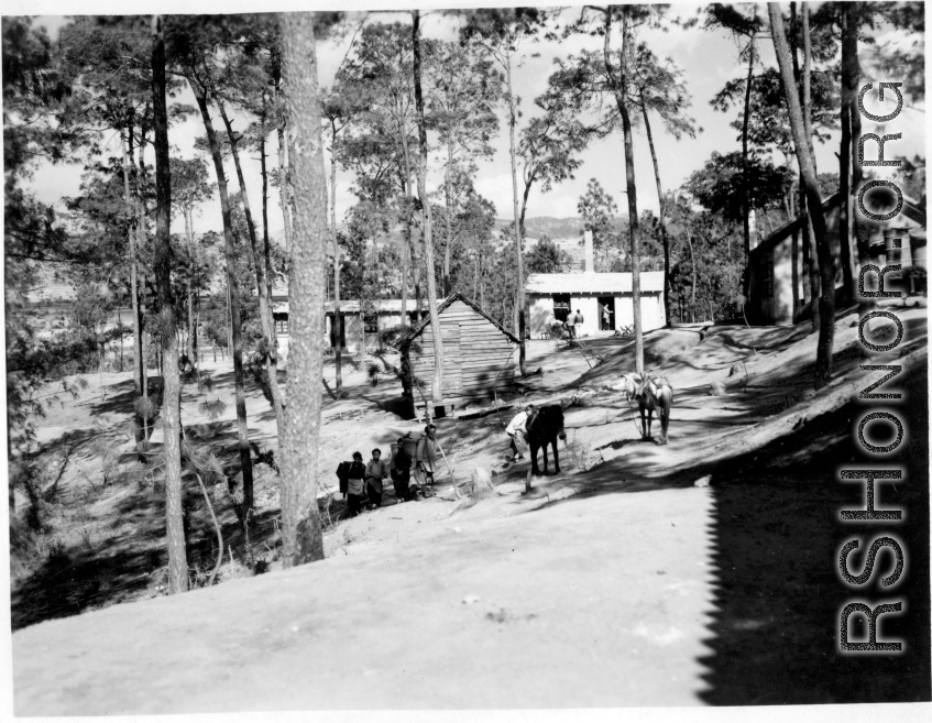 GI explorations of the hostel area at Yangkai air base during WWII: Local people move between the trees and buildings on the base.