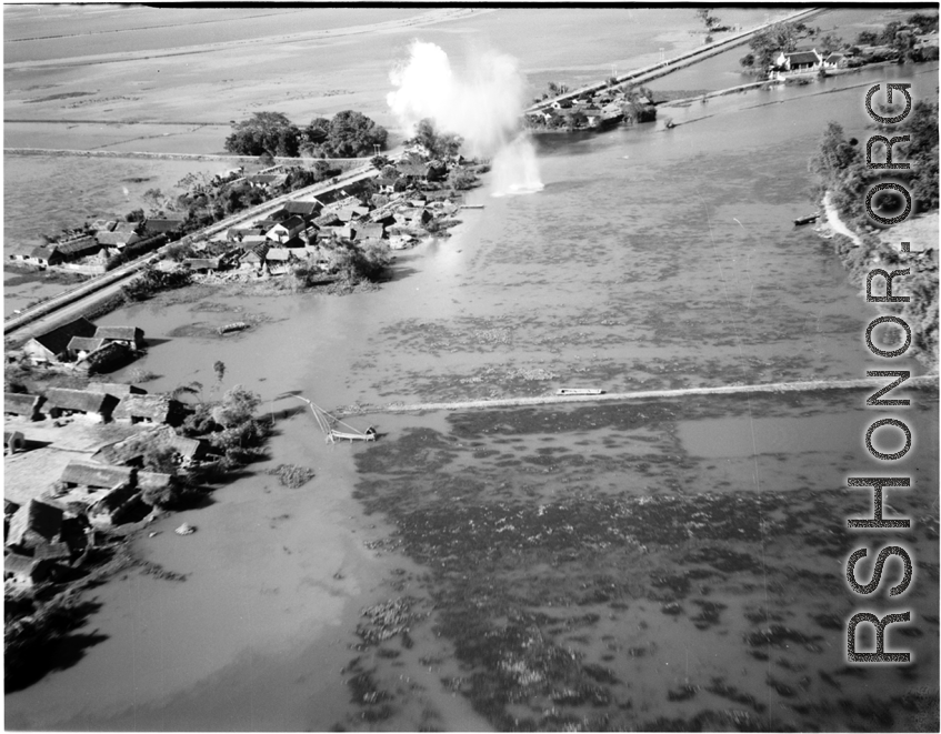 Bombing of small rail bridge, among a flood plain, in French Indochina during WWII.