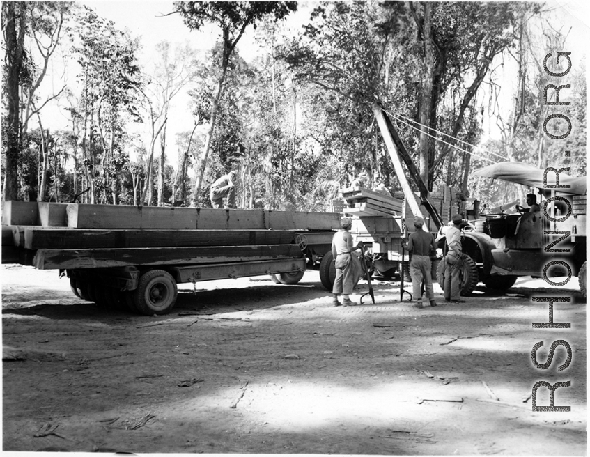 GIs load cut lumber at saw mill in Burma for transport to sites of bridge building.  During WWII.  797th Engineer Forestry Company.