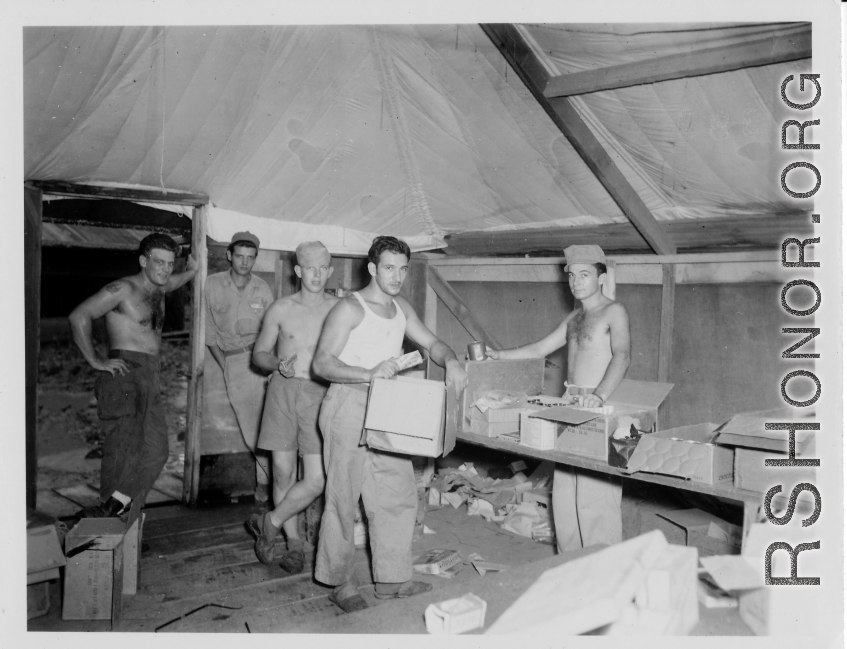 Burma Road engineers pick up goodies at camp in Burma--including Butterfinger bars, soap, chocolate syrup, etc.  During WWII.