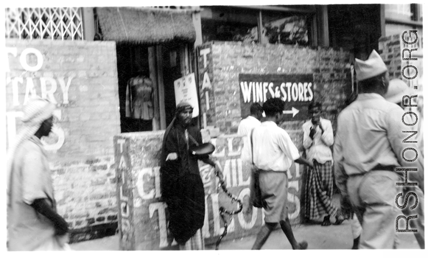 A fakir on the street in India, as an American Black GI walks by, as seen by men of the 2005th Ordnance Maintenance Company, 28th Air Depot Group, in India during WWII.