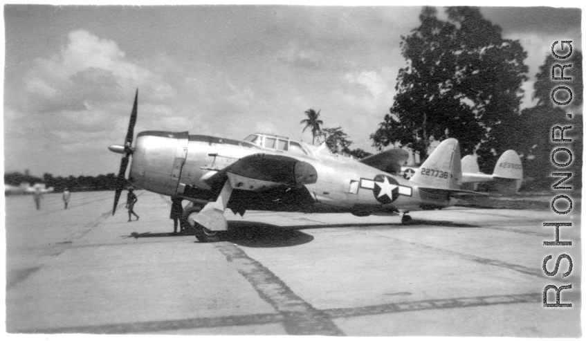 A Republic P-47B Thunderbolt, tail #227738, on pavement at an airbase in in Burma during WWII. P-38 #423800 is behind.