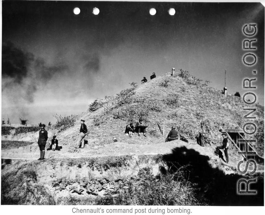 Pyramid-shaped air raid shelter used by Chennault in Kunming during WWII, in the midst of an air raid. In this image, Chennault is standing toward left, looking at the Japanese bombing out of scene of the left. In the middle, an American GI makes plots on a map board. Air vents can be seen protruding from the top, and garden vegetables grow in front.  Note also the female professional staff. A woman, probably a westerner, sits next to the GI with the map board, and another woman, likely of Chinese descent, 