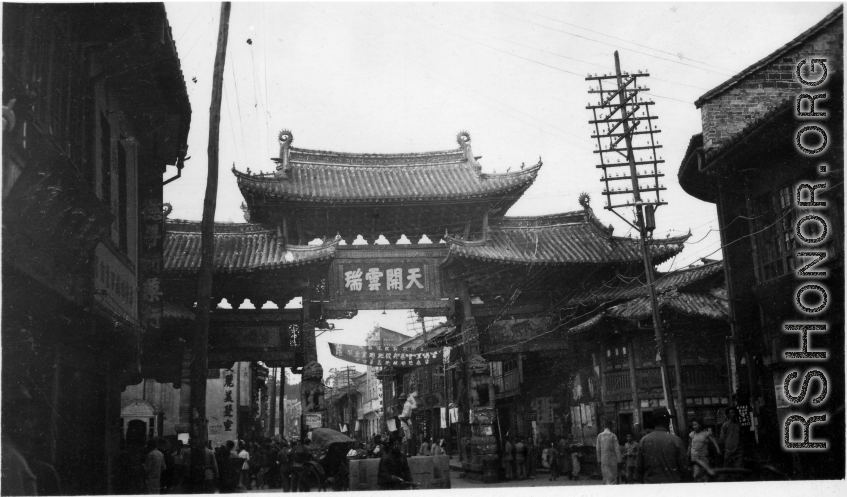 Street scene in Kunming, China, and arch with "天开云瑞"坊. During WWII.