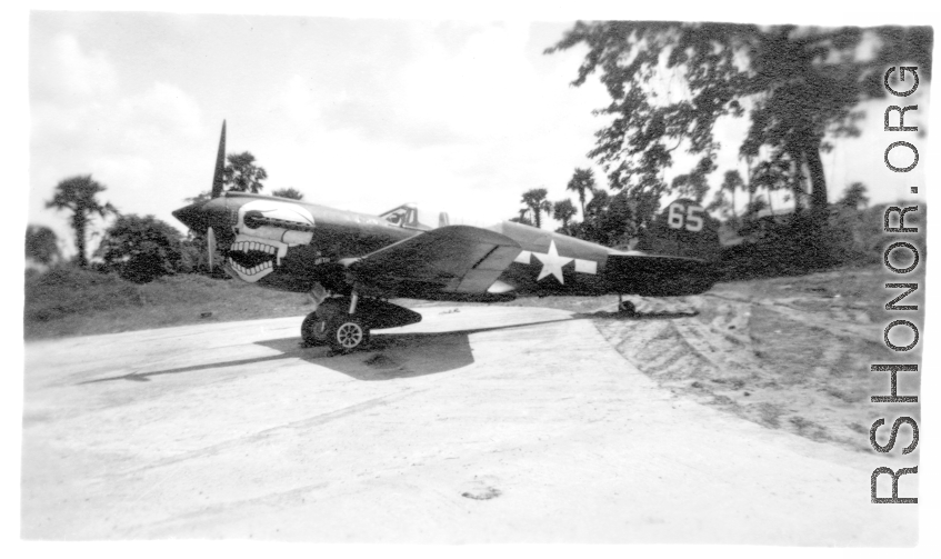 P-40 fighter #65, probably tail #2105234, of the 80th Fighter Group, the “Burma Banshees,” on pavement at an airbase in in Burma during WWII.