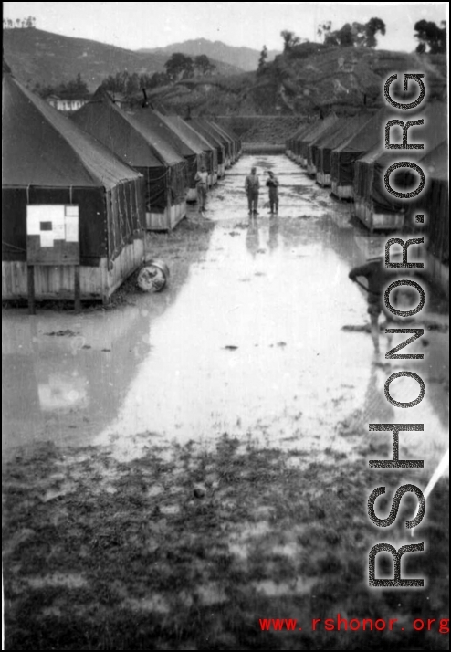 Tent city of flooded living quarters at Liangshan. Stream next to the site has overflowed in this image. During WWII.