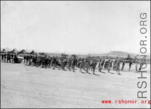 Laborers pull roller at Liuzhou during WWI, in 1945. GI tents can be seen in the distance.