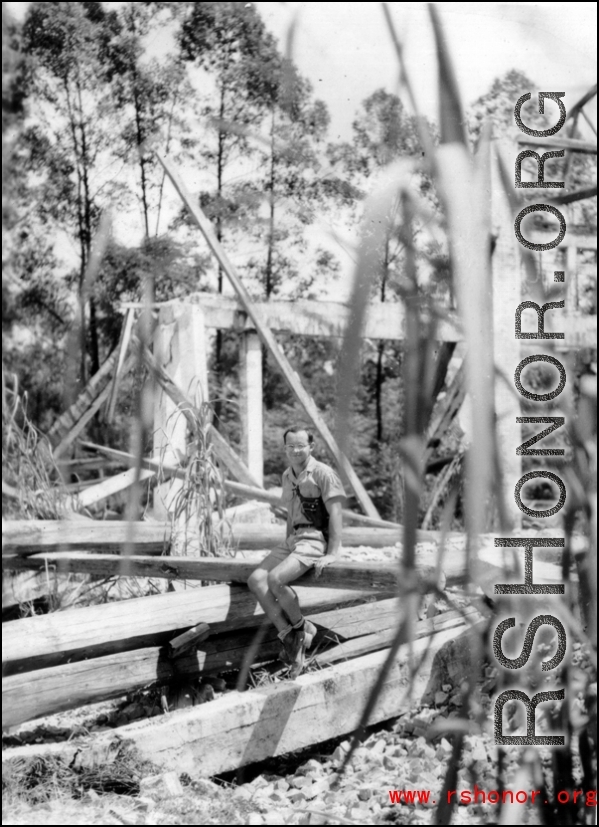 Friend of Bob Riese poses amongst remains of aircraft factory and hangers at the air base at Liuzhou, in 1945. The facilities at the base were first destroyed by the Chinese and Americans during retreat in the face of Ichigo during the fall of 1944, then may have been destroyed more by American bombardment during Japanese occupation, and possibly destroyed more by the Japanese as they retreated the area in 1945.