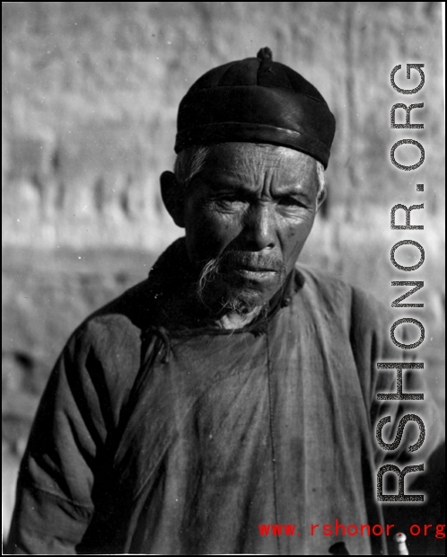 An elderly man poses for the photographer in China during WWII.