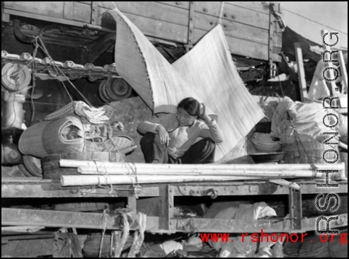 Chinese refugee waits atop flatbed car at the train station in Liuzhou during WWII, in the fall of 1944, as the Japanese advanced during the Ichigo campaign.