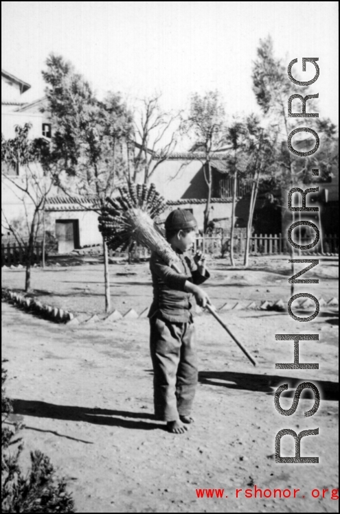 A young candied fruit seller selling candied haws fruit on bamboo skewers during WWII.