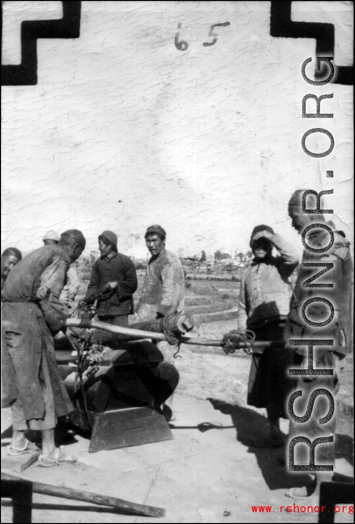 Rural men carry a wooden coffin in SW China during WWII.