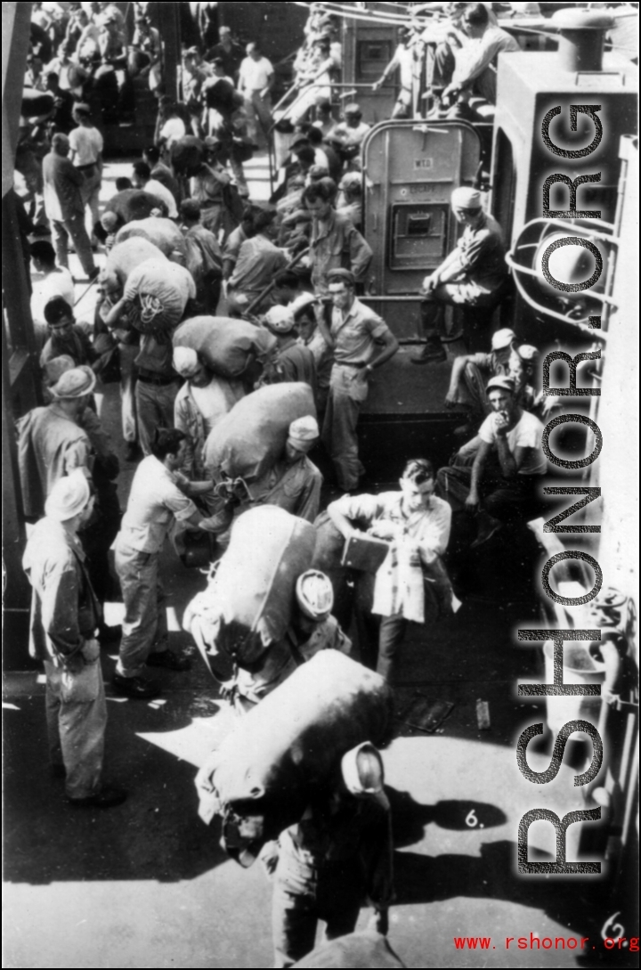 GIs board ship on the way back to the US after the war. The ship is probably the SS Marine Raven.