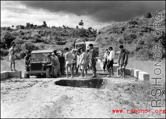 Getting a few last vehicles across a bridge at Liuzhou before the Japanese advance in the fall of 1944. The bridge decking planks have been removed, but there are enough free planks that by moving a few planks, then moving forward a bit on those planks, then moving a few more planks, the jeep can creep across.