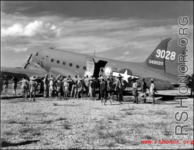 A C-47 (tail #349028) of the Air Transport Command (ATC) on the ground with Chinese laborers in the foreground.