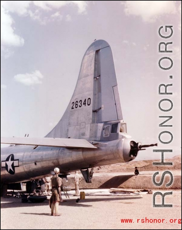 A B-29 bomber, tail number 26340, under maintenance, with a Chinese soldier standing guard, in the CBI.