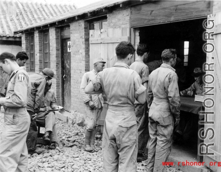 "'Stateside' folding money being handed out on payday by Lt. COl. John H. Williamson, CO of the Fourteenth Air Force Transport Unit to men of his command."