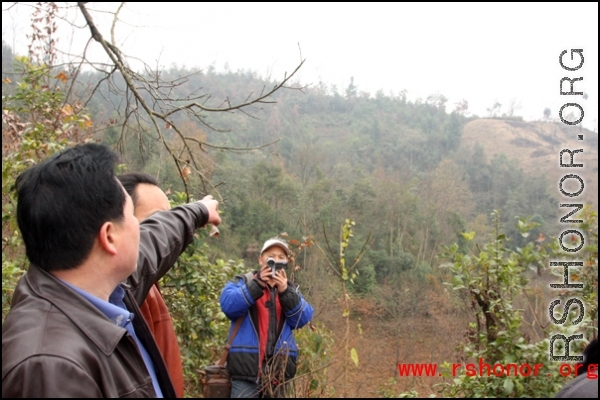 Mr. YA pointing to the hillside where the plane crashed.  Villagers say the plane came in at night, in the dark, then circled dropping flares, before finally crashing.  A large number of Chinese soldiers were on the plane, supposedly just returned from training abroad, and all died, along with the two Americans. At least one additional American bailed out of the airplane, was injured, but ultimately survived, and was taken from the valley a couple days after the crash.