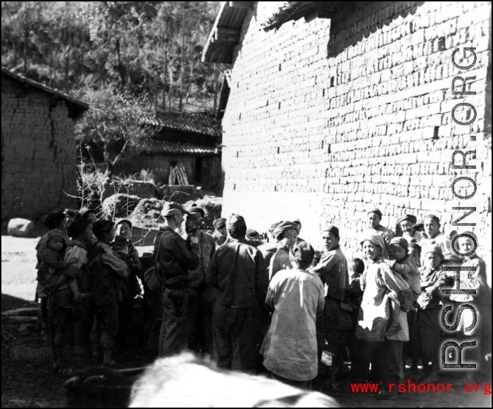 An American photographer interacts with local people in a village in Yunnan during WWII.