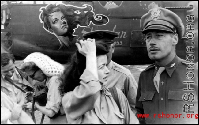 Ann Sheridan (white knitted hat) signs an autograph, with Ruth Dennis in the center foreground. Along with Mary Langdon and Ben Blue they were at Yangkai Air Base, China, on a USO tour in the CBI. In this photo they had just finished helping the 22nd Bomb Squadron dedicated their aircraft 'Sheridan Express' . John A. Johns (22nd B.S., deceased) painted the nose art just before Miss Sheridan arrived at Yangkai. After the war John became rather famous for his caricature art.