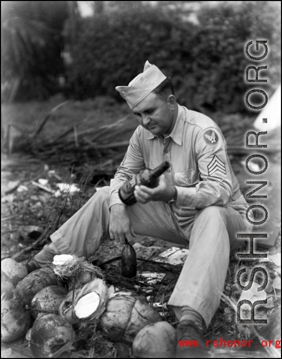 An American in the CBI sorts through booze bottles and coconuts during WWII.