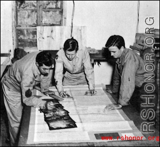 Men from the 21st Photographic Reconnaissance Squadron examine some photographs. In China, during WWII.