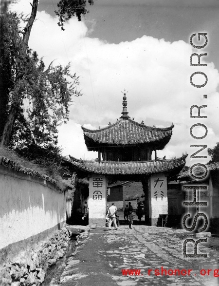 Local people and a whitewashed gate in Luliang, Yunnan province, China. During WWII.