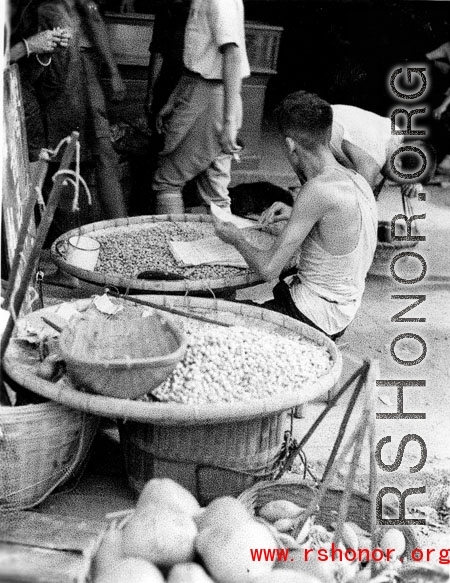 Local people selling peanuts in a market in Yunnan province, China. During WWII.