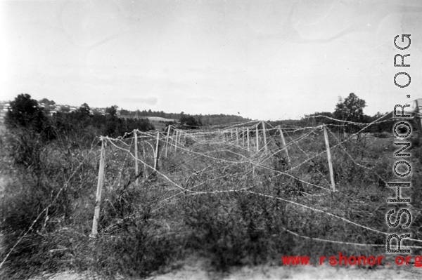 Barb wire grid on posts in China, Burma, or India. During WWII.