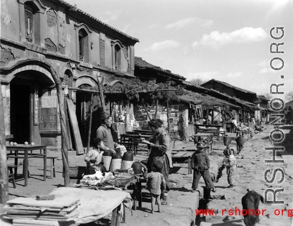 Local people in a village in Yunnan province, China: A quiet market street near Kunming on a non-market day. During WWII.