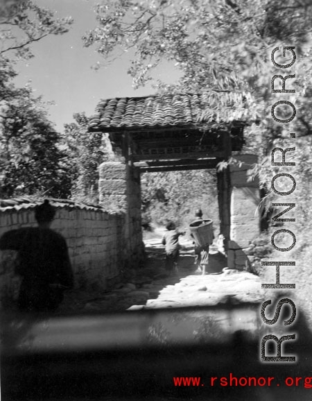 Villagers going through a narrow village gate in Yunnan province, China.