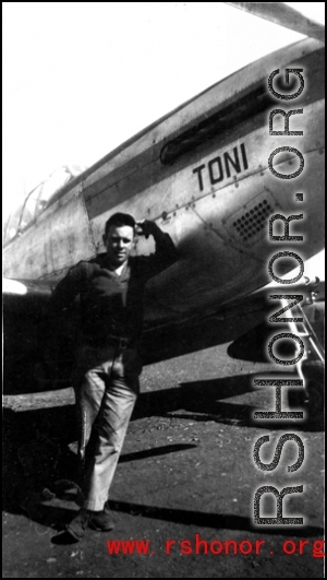 An American serviceman stands next to a P-51 fighter named "Toni".