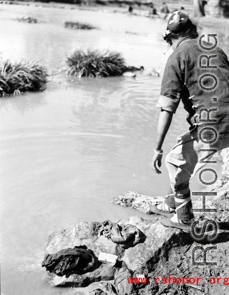 A women washes clothes near Yangkai, Yunnan province, China, during WWII.