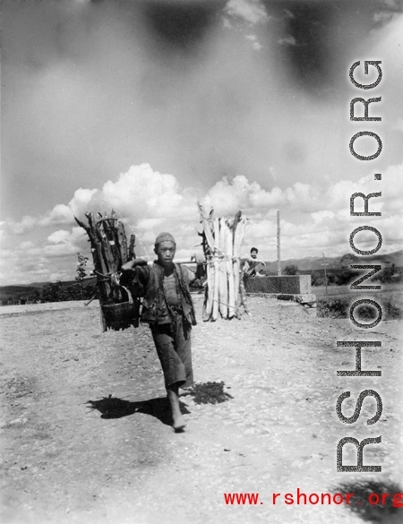 Man shouldering firewood in Yunnan during WWII.