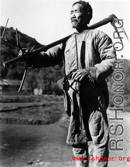 Local people in China: A Chinese farmer in Yunnan poses with a farming implement. During WWII.