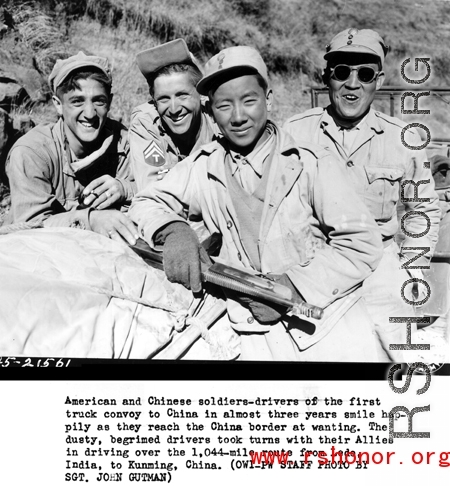 American and Chinese soldiers--drivers of the first truck convoy to China in almost three years smile happily as they reach the China border at Wanting.  The dusty, begrimed drivers took turns with their Allies in driving over the 1,004-mile route form Ledo, India, to Kunming, China. During WWII.   (OWI-PW staff photo by Sgt. John Gutman)