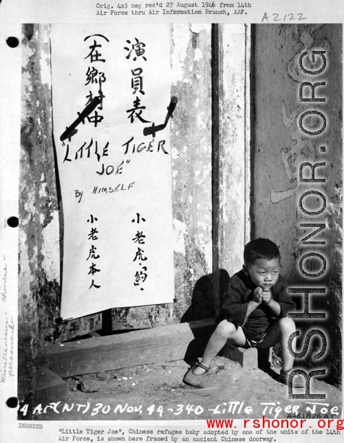 "Little Tiger Joe," Chinese refugee baby adopted by one of the units of the 14th Air Force, is shown here framed by an ancient Chinese doorway, during WWII in China.