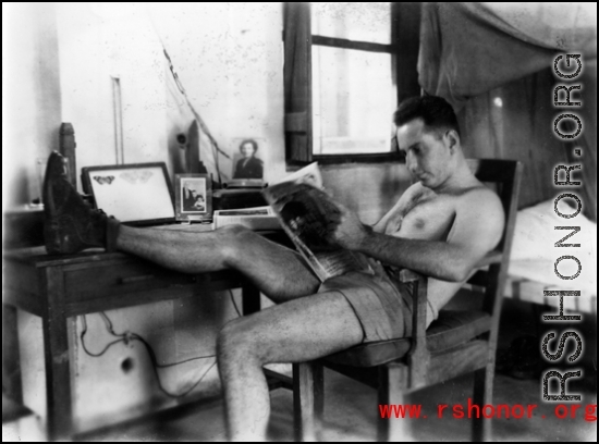 David Firman reads a magazine in his quarters in China during WWII.   From the collection of David Firman, 61st Air Service Group.