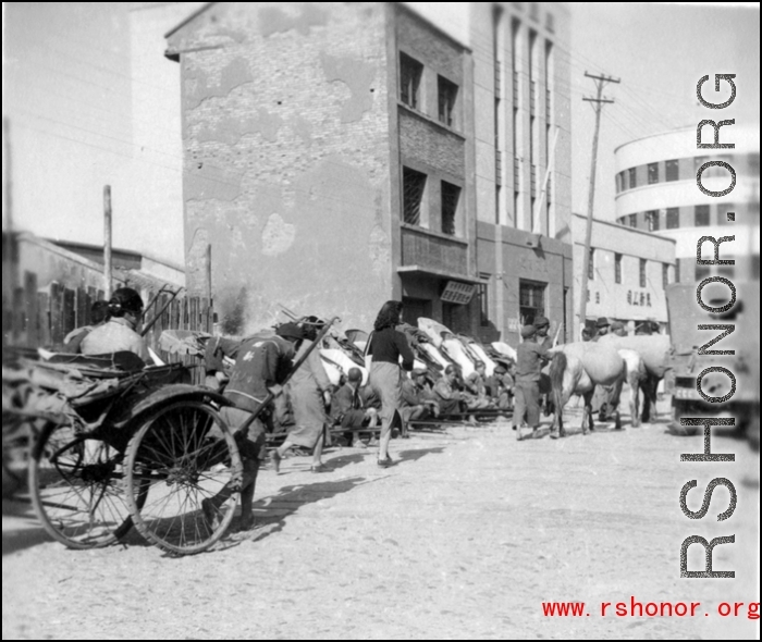 Scenes around Kunming city, Yunnan province, China, during WWII: Street and lined up rickshaws.