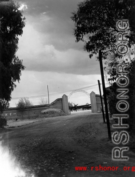 The gate of an airbase in Yunnan province, China, with a C-46 transport showing. During WWII.