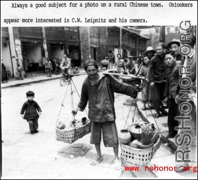 A Chinese vendor carries his goods on a shoulder pole in the CBI during WWII.  Photo by C. W. Leipnitz.