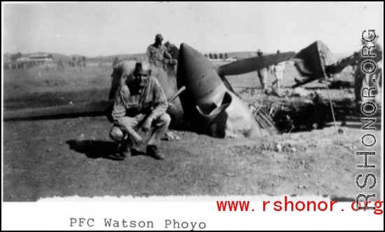 GI kneels before destroyed P-40 fighter in the CBI.  Photo from PFC Watson.