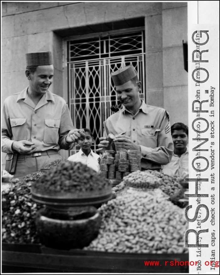 Bob Lichty (left) and John Darnell, both "sporting Indian caps," check out a nut vendor's stock in Bombay, India, during WWII.  Photo from Bob Lichty.