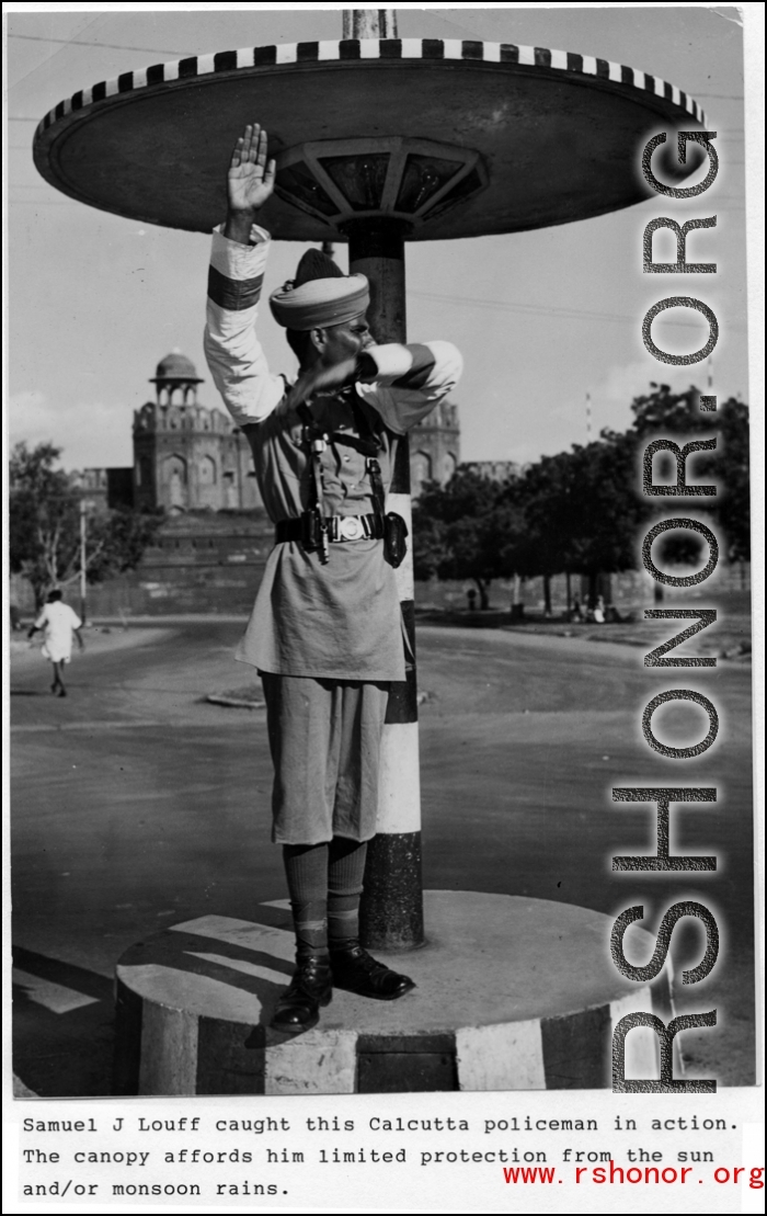 A Calcutta traffic policeman directs traffic from his raised stand from under a canopy.   Photo from Samuel J. Louff.