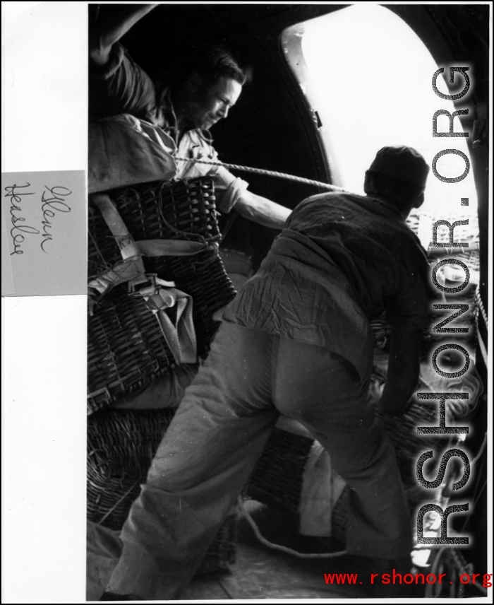 Men push woven baskets, with attached parachutes, out of a cargo plane mid air as part of an air drop in the CBI.   Photo from Glenn Hensley.