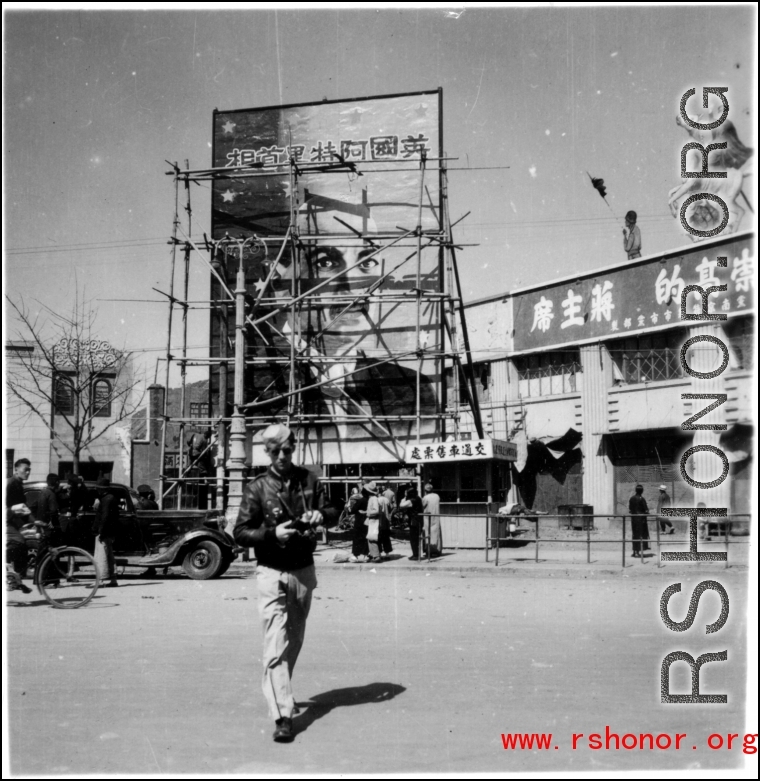 A GI walks on a Kunming street with slogans about Chiang Kai-shek in the background, and an image of British politician Clement Richard Attlee.