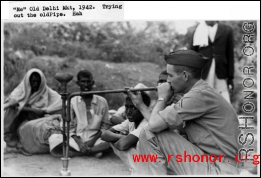 A GI tries out a smoking pipe in the old Delhi market in 1942.